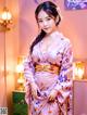 A woman in a pink kimono posing for a picture.