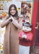 A woman standing in front of a restaurant with a statue of a girl.