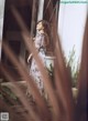 A woman standing in front of a window in a dress.